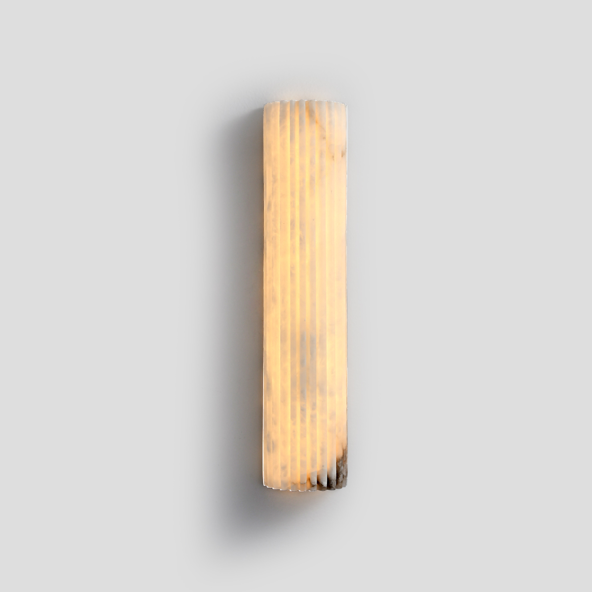 Valerie Fluted Alabaster Wall Sconce 1 Fluted natural alabaster LED wall sconce lit up showing warm ambient glow.